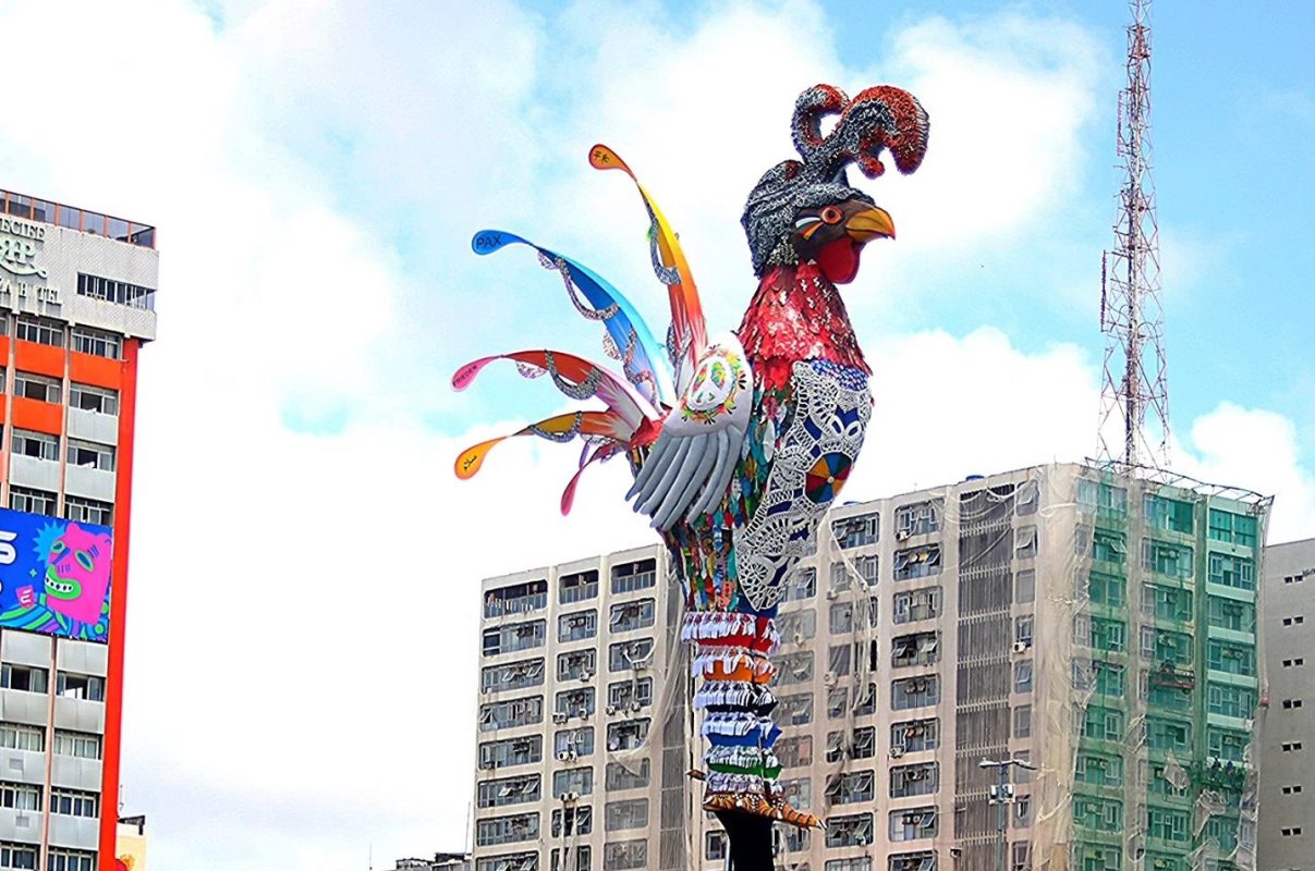 A alegoria gigante do Galo da Madrugada com as Varandas da Paz coloridas e com feitas com fibra de tecido por artesãs inspiradas em técnica tradicional de indígenas da etnia Pankararu (Foto: Galo da Madrugada)