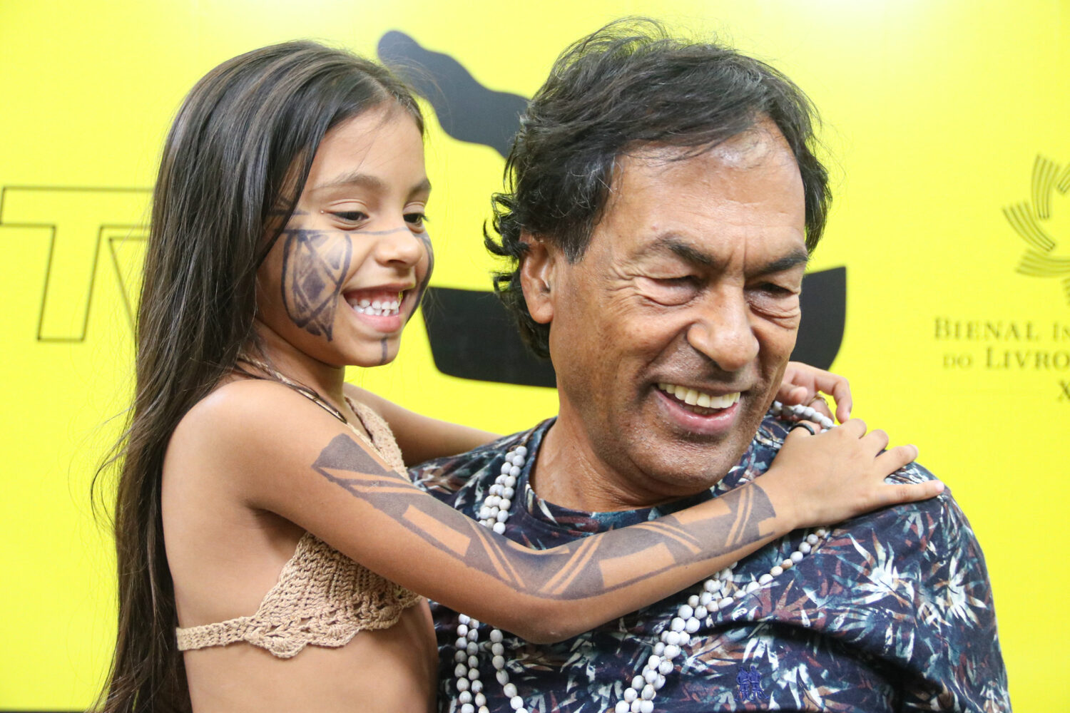 Krenak com uma criança indígena na Feira do Livro do Ceará: livros traduzidos em 19 países (Foto: Salvino Lobo/Divulgação)