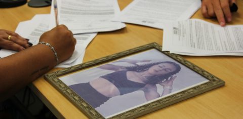 A família de Amanda com sua foto e os novos documentos: dignidade póstuma após transfeminicídio (Foto: Carolina Calháu / Defensoria Pública RJ)