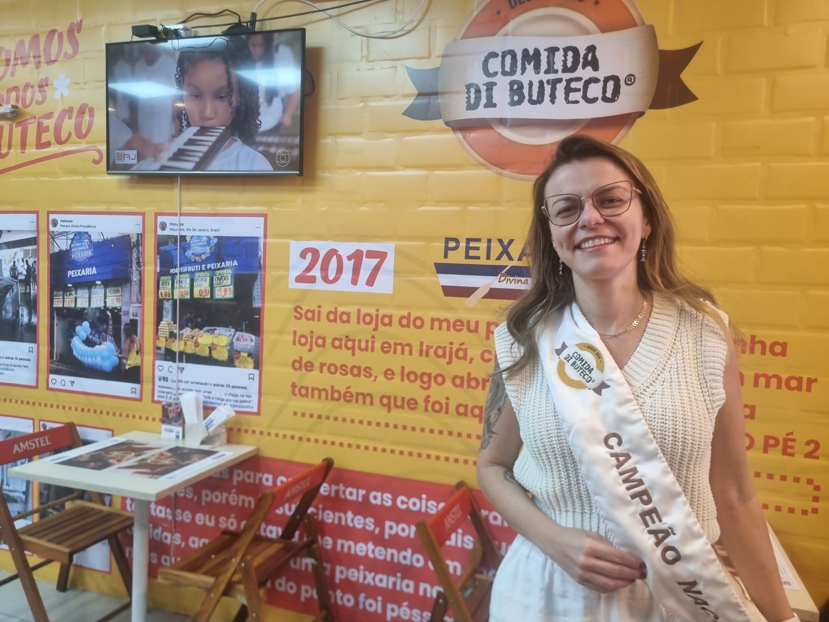 Manuela Ornelas e sua faixa de campeã nacional do Comida Di Buteco no Bar da Peixaria Divina Providência: história de sucesso em Irajá (Foto: Oscar Valporto)