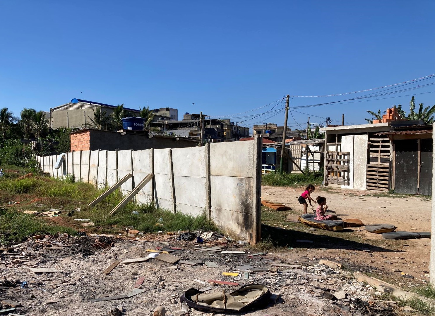 Crianças brincam junto a muro que separa Vila da Paz de terreno vizinho de onde famílias já foram removidas: só durante a pandemia, 19 mil famílias despejadas de suas casas em todo o país (Foto: Isabela Alves)