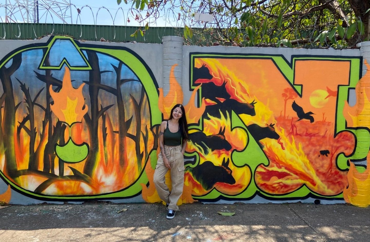 Nath, uma das autoras, à frente do mural denunciando desmatamento e seca na Amazônia: arte contra o caos climático (Foto: Rainer Almeida)