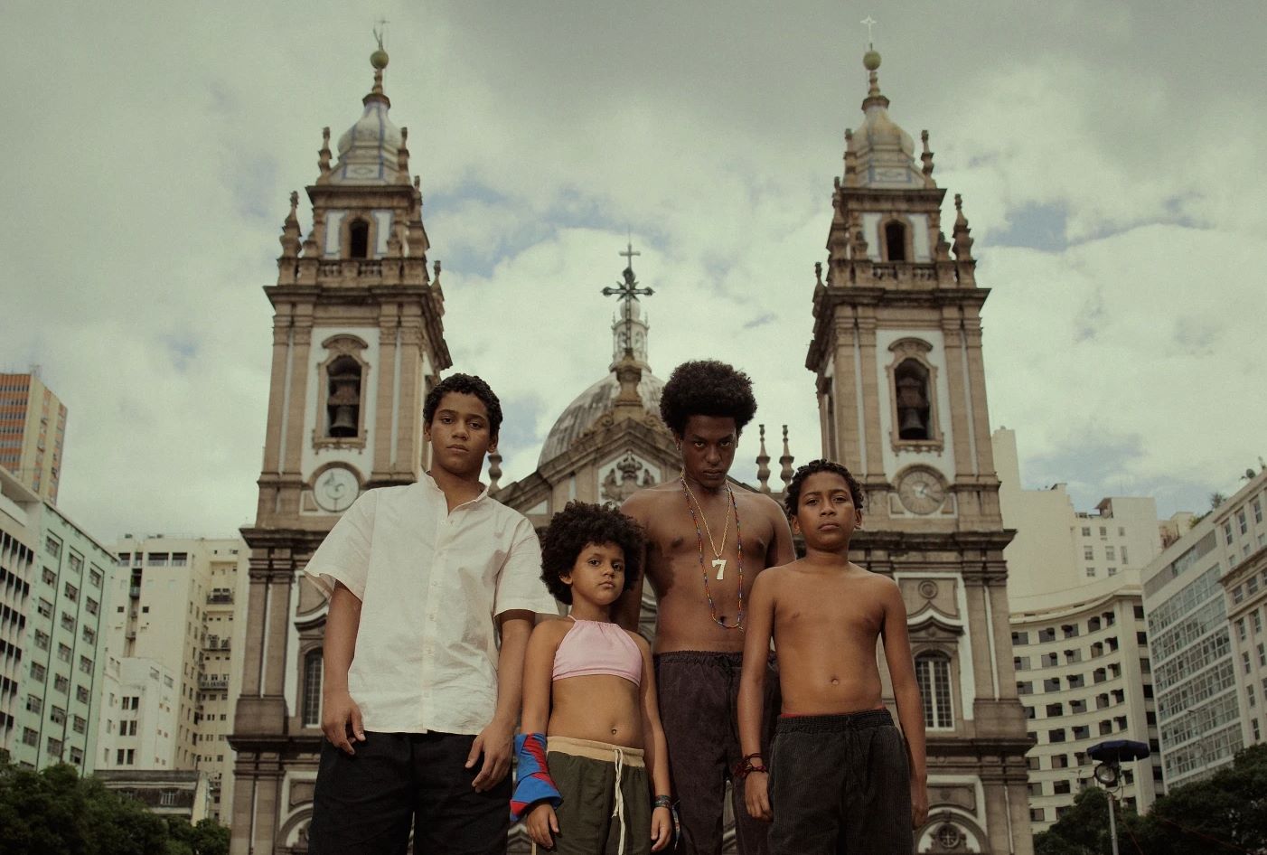 Os atores de Os Quatro da Candelária - Andrei Marques (Jesus), Wendy Queiroz (Pipoca), Patrick Congo (Sete) e Samuel Silva (Douglas) - em frente à igreja: 31 anos depois da chacina, crianças e adolescentes em situação de rua continuam à mercê da violência (Foto: Netflix / Divulgação)