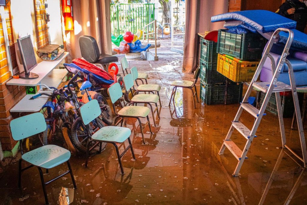 Escola da rede municipal de Porto Alegre alagada pelas chuvas: alunos saindo e chegando na capital após as enchentes (Foto: Júlia Azevedo / Prefeitura de Porto Alegre)