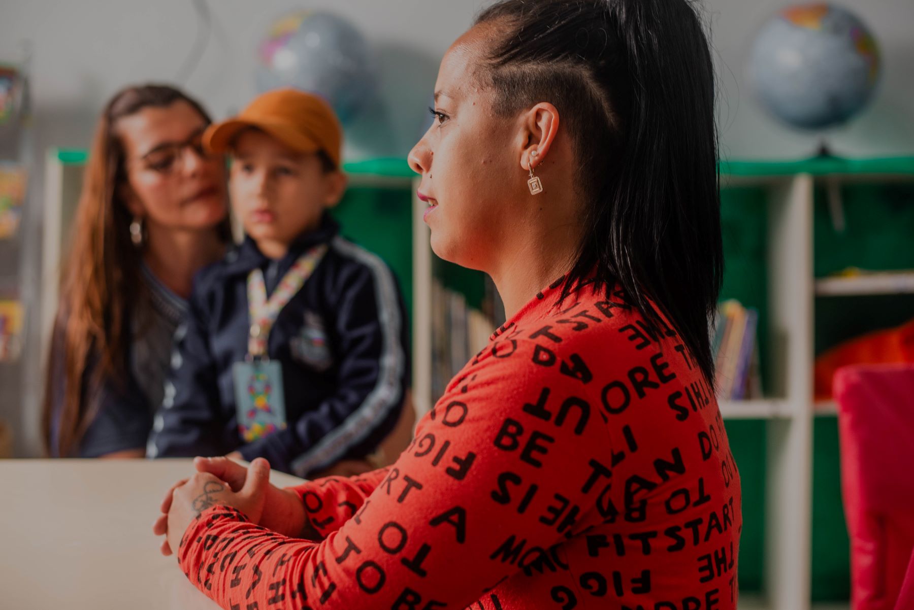 Luana dos Santos e o filho Lorenzo, no colo da professora Kellen na escola em Tramandaí: bom acolhimento da criança facilitou adaptação após a enchente (Foto: Auryn Souza)