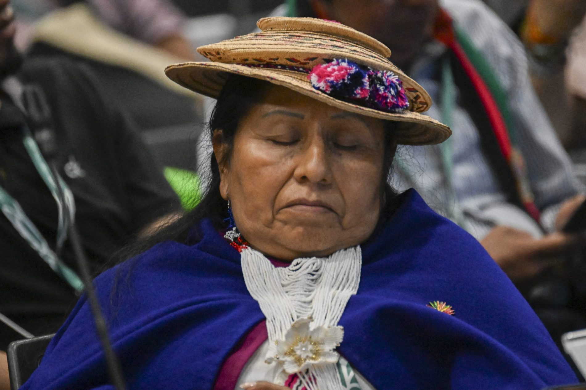 Mulher indígena descansa enquanto participa da última sessão plenária da COP16, em Cali. As negociações entraram pela madrugada. Foto Joaquin Sarmiento/AFP