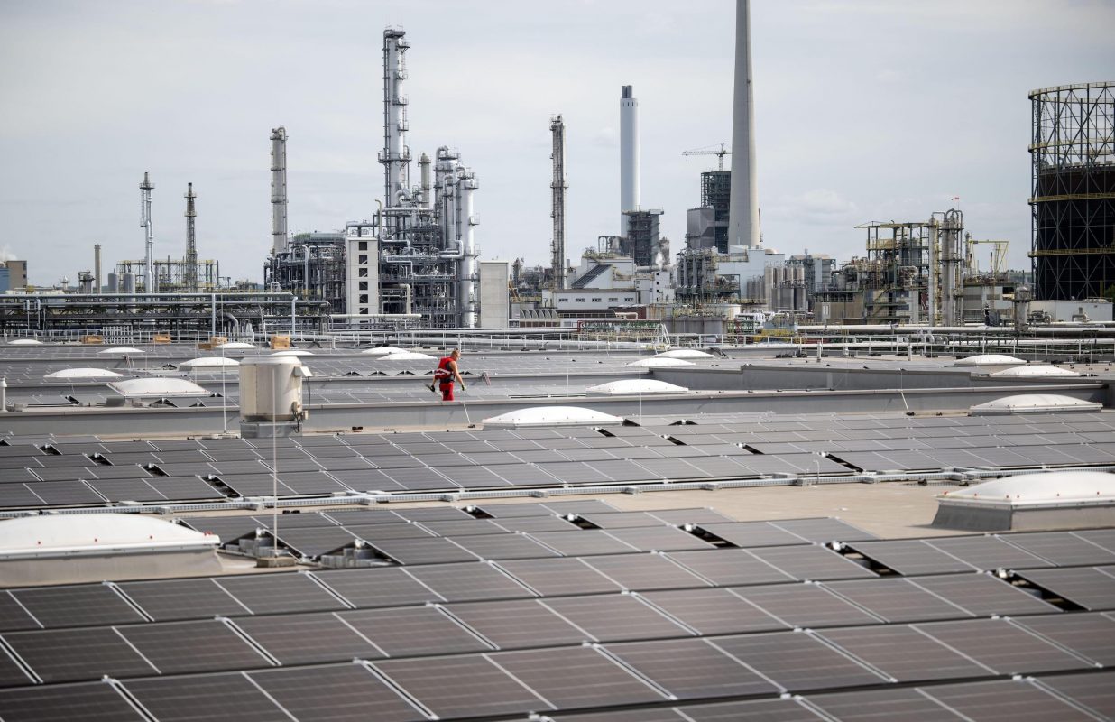 Um trabalhador caminha por paineis solares antes da inauguração da usina de 12 megawatts em um centro de logística alemão. A usina é a maior instalação em telhado da Alemanha. Foto Bernd Thissen / Alamy