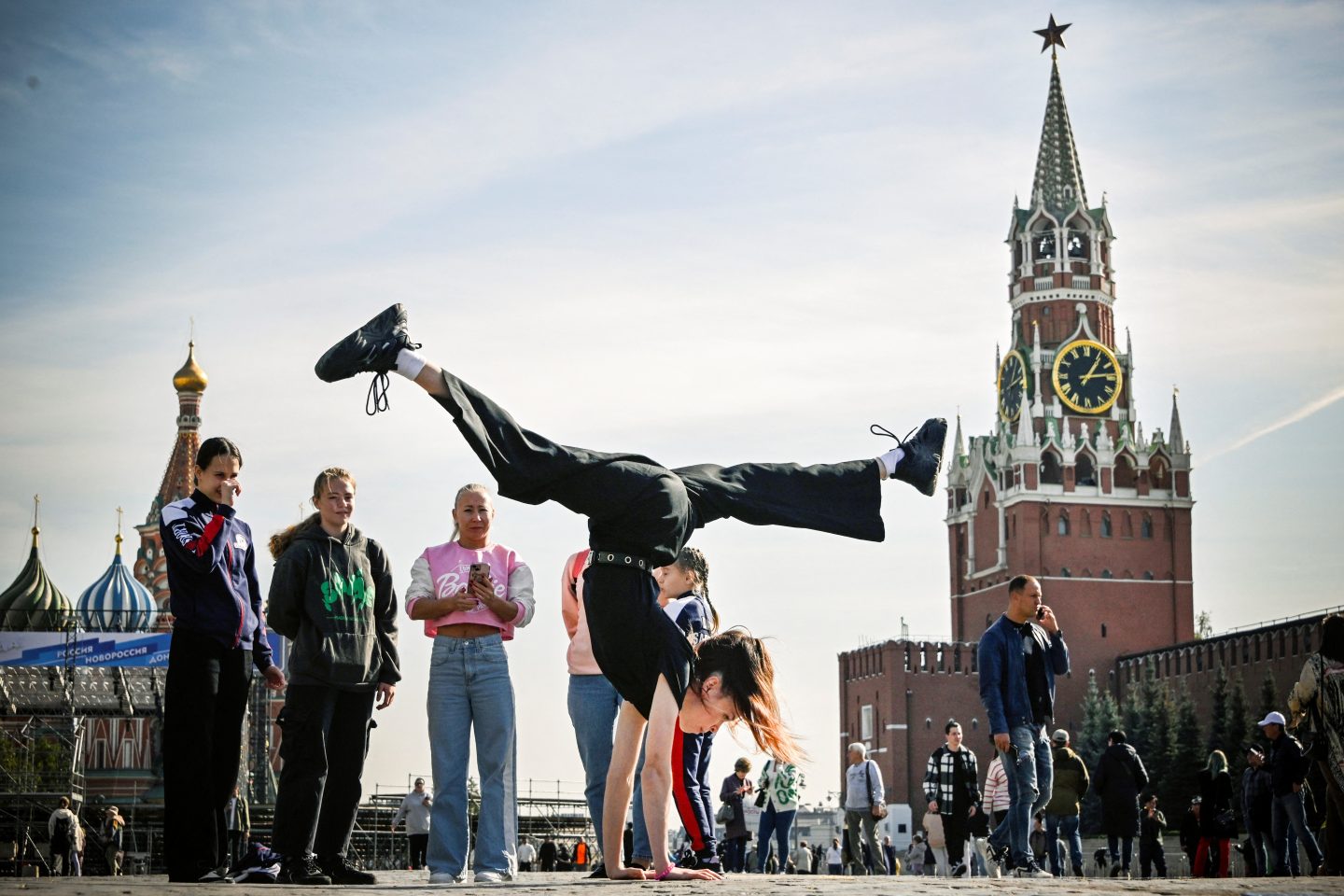 Ginasta russa posa para uma foto na Praça Vermelha, em frente ao Kremlin e à Catedral de São Basílio, no centro de Moscou. País enfrenta "inverno demográfico" com boas possibilidades de crescimento. Foto Alexander NEMENOV/AFP. Setembro/2024