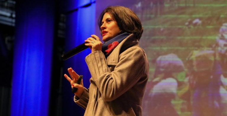 Foto colorida de Débora Noal durante apresentação no ConBrasCC