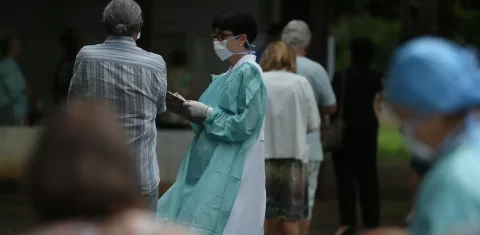 Foto colorida de fila de pessoas idosas para receber vacinas contra Influenza; envelhecimento da população desafia sistema de saúde