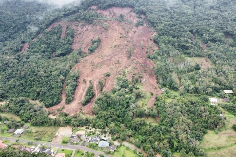 Foto colorida de deslizamento de terra em Picada Café, no Rio Grande do Sul. Na imagem de satélite, aparecem as cicatrizes por onde ocorreu os movimentos de terra, em meio às árvores da encosta