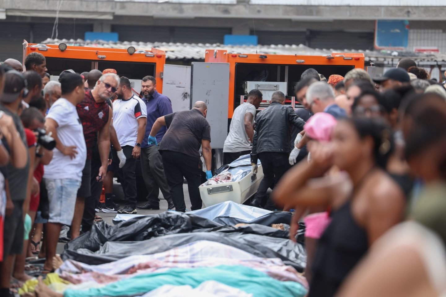 Funcionários do IML retiram cadáveres de praça na Zona Norte do Rio: 121 mortos e denúncias de execuções e torturas (Foto: Tomaz Silva / Agência Brasil)