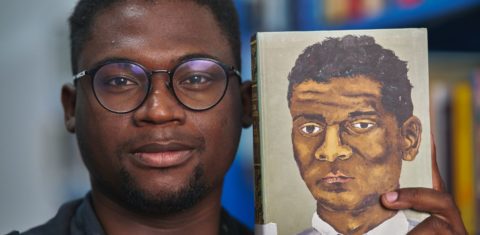 Matheus Euzébio com livro de Lima Barreto na biblioteca batizada com o nome do escritor na Maré: “Já ouvi muitos depoimentos de pessoas que, de alguma forma, foram transformadas por esse lugar" (Foto: João Werneck)