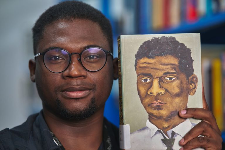 Matheus Euzébio com livro de Lima Barreto na biblioteca batizada com o nome do escritor na Maré: “Já ouvi muitos depoimentos de pessoas que, de alguma forma, foram transformadas por esse lugar" (Foto: João Werneck)