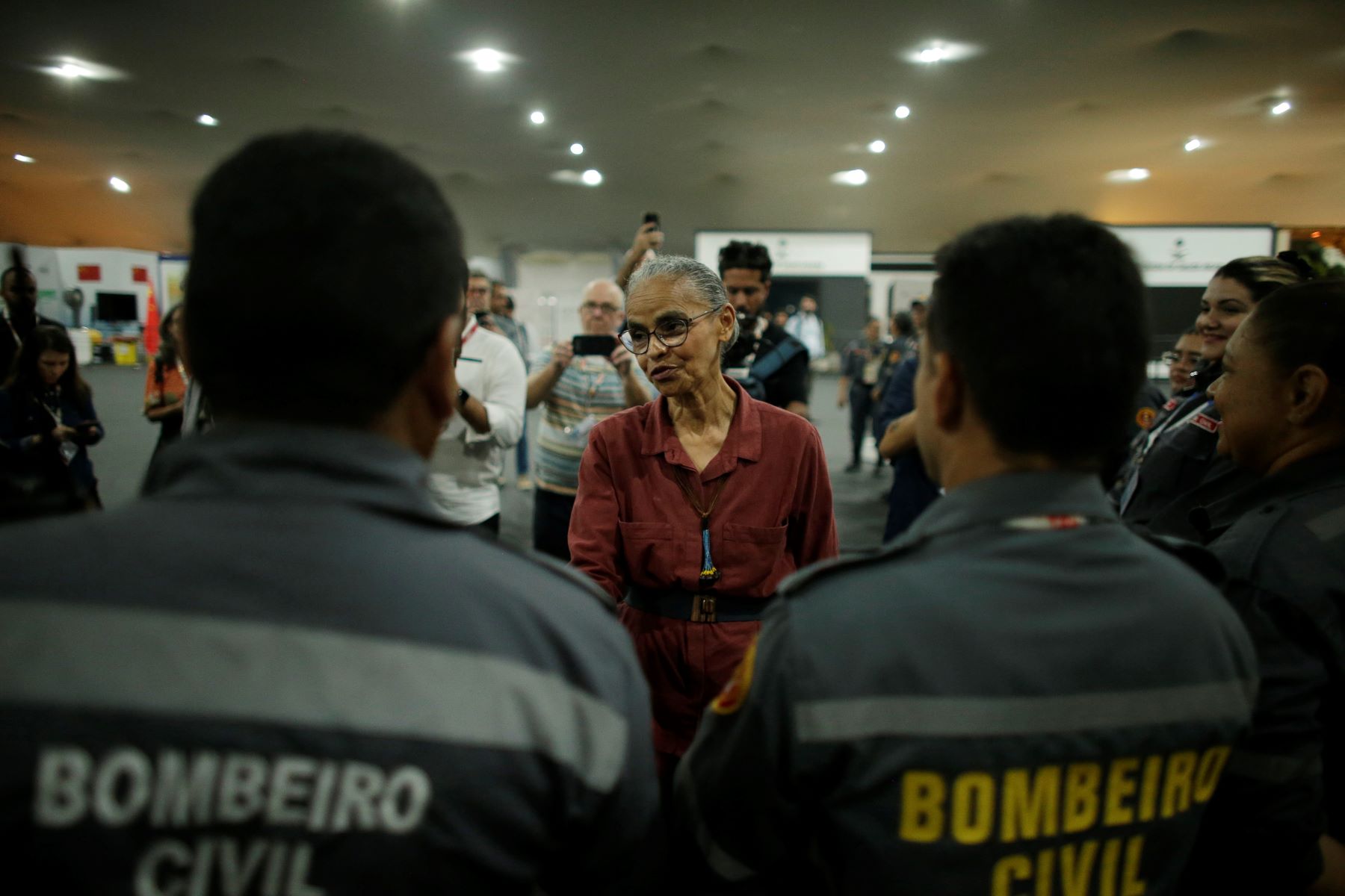 A ministra Marina Silva com bombeiros na noite de quinta-feira: após trabalho pela madrugada, novo texto apresentado pela presidência da COP30 é alvo de duras críticas (Foto: Raimundo Pacco / COP30)