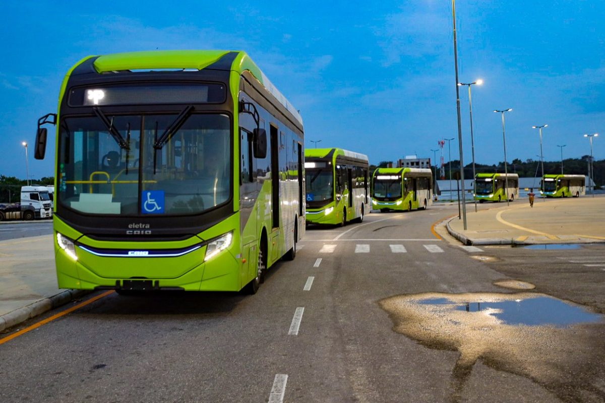 Foto colorida de ônibus da COP30 de frente andando em rua de Belém