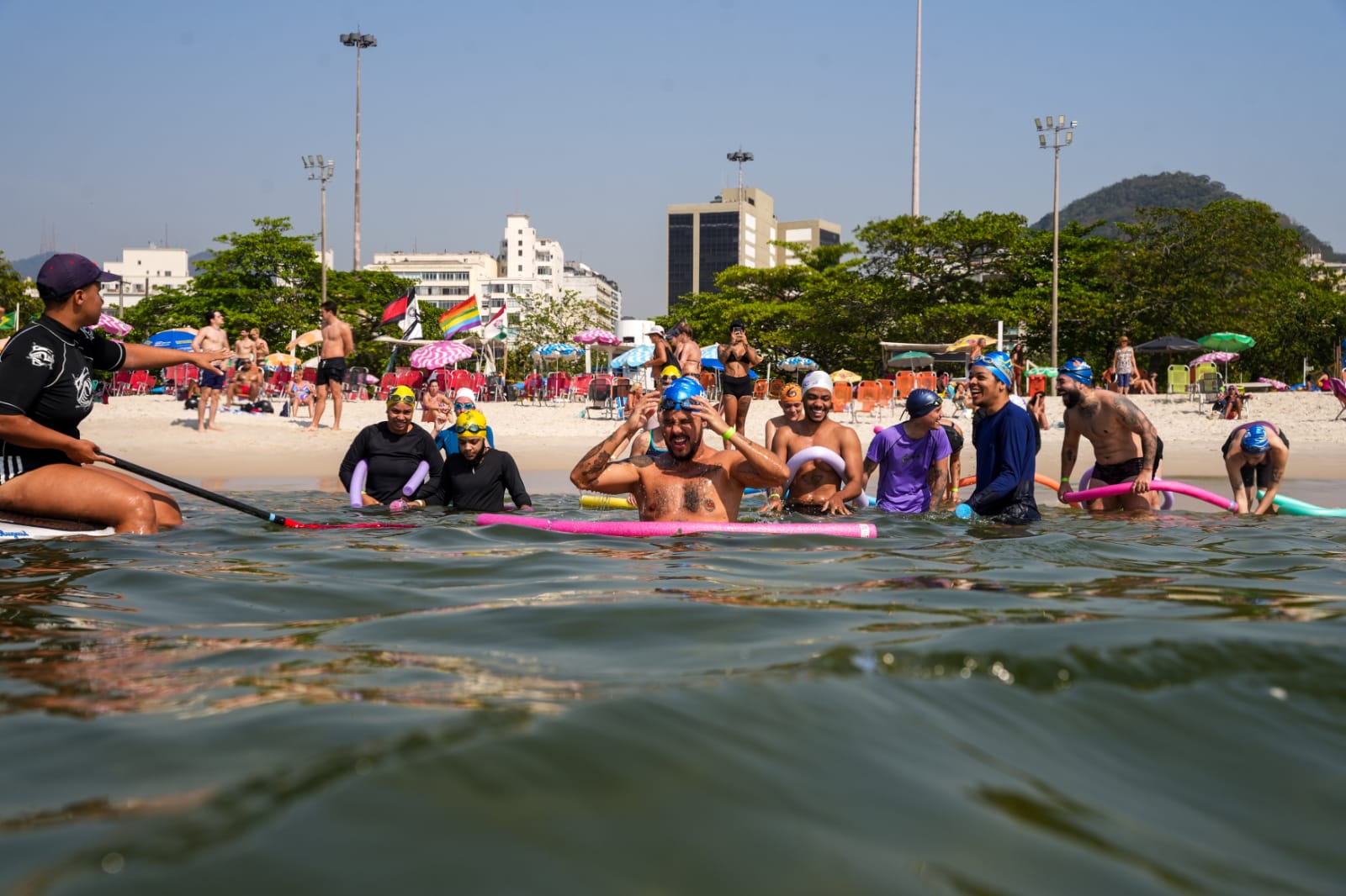 O professor Marcelo (à esquerda) com seus alunos na Praia do Flamengo: "a praia é o primeiro local em que as pessoas trans e travestis abandonam durante a sua transição" (Foto: Aquatrans / Divulgação)