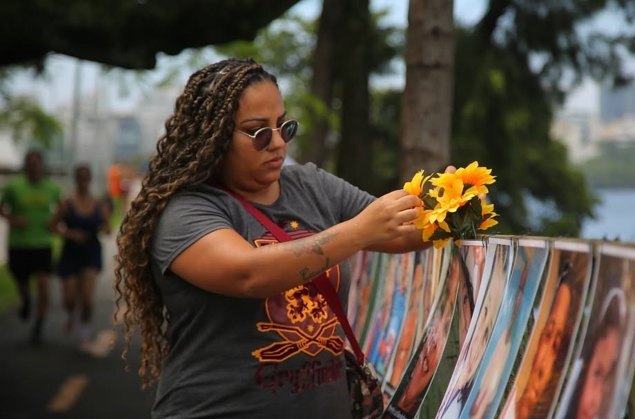 Thamires com girassóis, flores preferidas da filha: "a placa e as flores eram tudo que eu poderia fazer para pedir justiça" (Foto: Rafael Henrique Brito / ONG Rio de Paz - 28/12/2024)