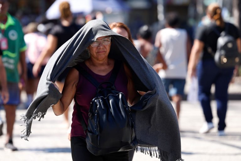 Idosa tenta se proteger do sol em dia de calor de mais de 40 graus no Rio: pesquisa apontou que o calor extremo tem um impacto comparável ao tabagismo e consumo excessivo de álcool na aceleração do envelhecimento (Foto: Tânia Rego / Agência Brasil - 17/02/2025)