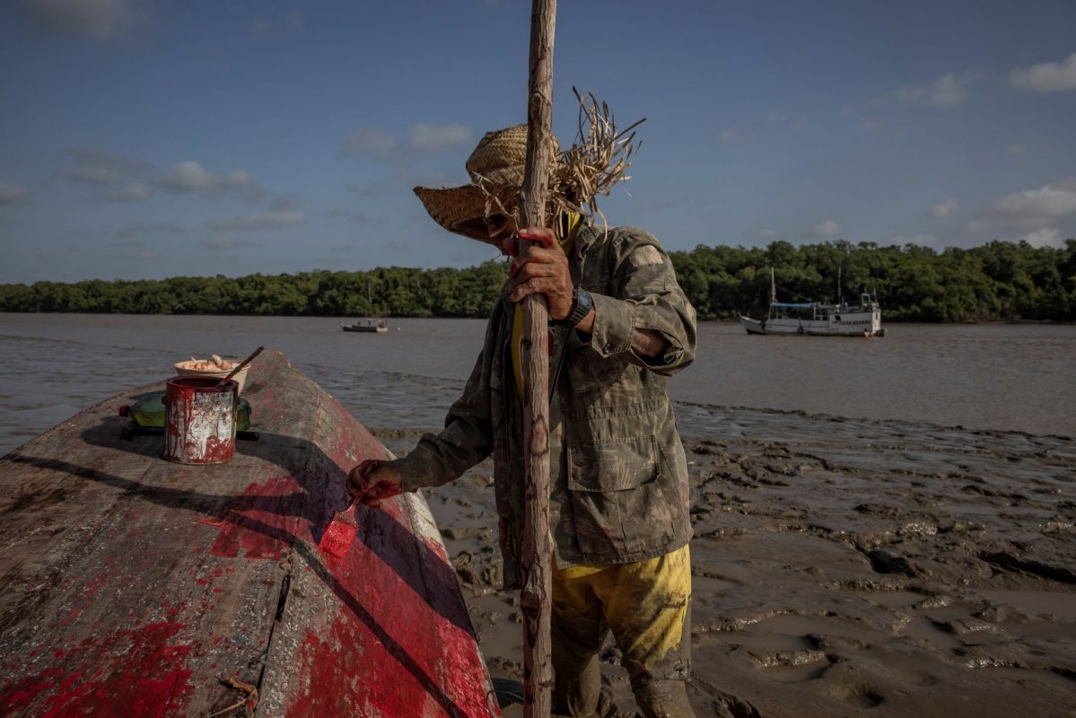 Pescador pinta embarcação em Sucuriju, na foz do rio Amazonas: comunidades tradicionais podem ser atingida por vazamento de petróleo (Foto: Victor Moriyama / InfoAmazonia)