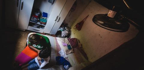 Jéssica Lima com o filho Kássio em casa num dia de calor extremo em Maceió: pobreza agrava os riscos das altas temperaturas para pacientes com transtorno de saúde mental (Foto: Jonathan Lins)