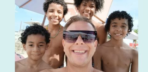 Alexandre Rank com os filhos adotados na praia em Salvador: “Adoção é família, adoção é cumplicidade. Então, para mim é uma família comum, como qualquer outra, porque laços sanguíneos não querem dizer nada" (Foto: Arquivo Pessoal)