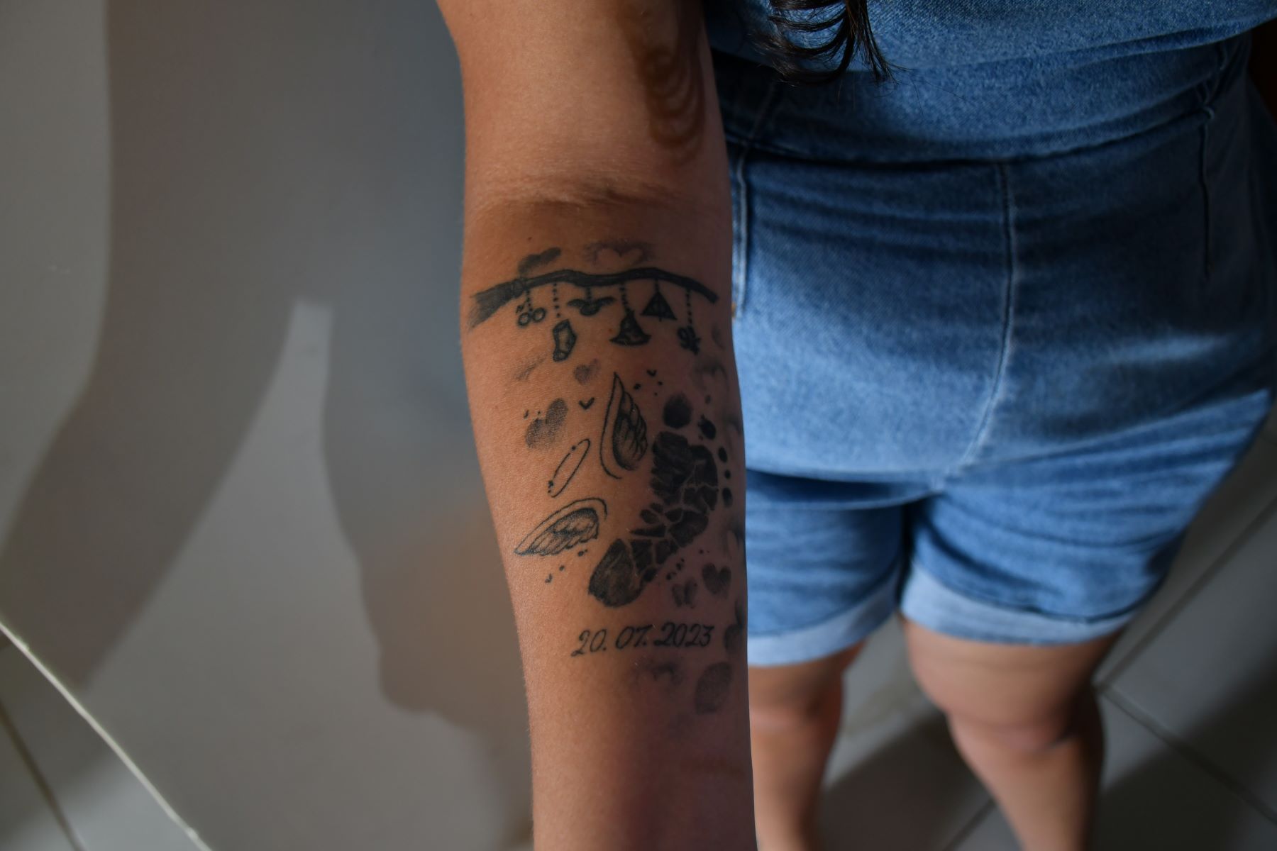 Juliana com as referências ao bebê perdido tatuadas no braço: denúncia de violência obstétrica no hospital (Foto: João Paulo Guimarães)