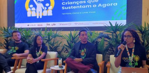 Foto colorida do painel: “Juventudes e crianças que sustentam o agora: território, clima e lutas vivas”. Na imagem, da esquerda para a direita, aparecem Marcelo, Fabrina e Vinícius e a mediadora Marta Melo