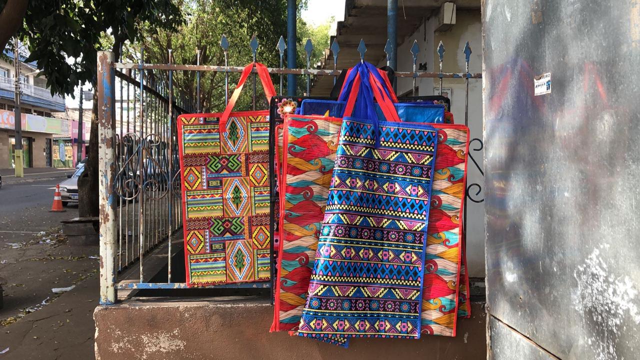Foto colorida que mostra sacolas coloridas, fruto de trabalho artesanal de mulheres migrantes
