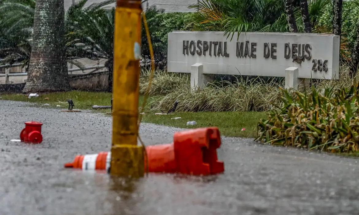 Foto colorida de placa do hospital Mãe de Deus em Porto Alegre durante enchentes de maio de 2024