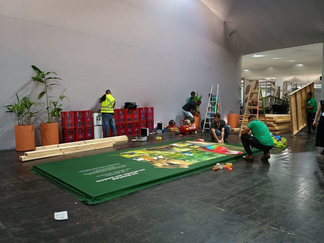 Foto colorida de pessoas trabalhando em montagem de estrutura para a COP30