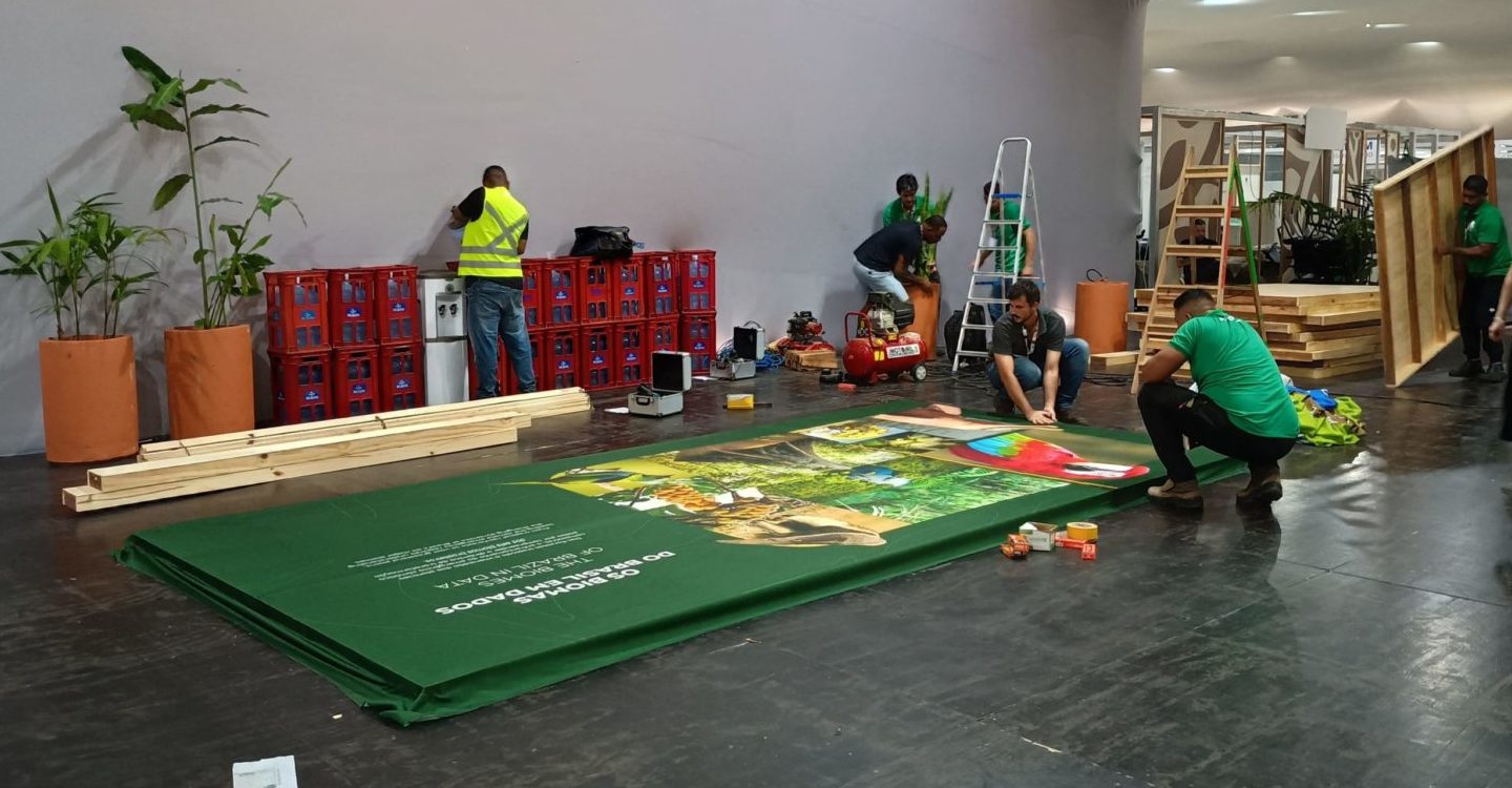Foto colorida de pessoas trabalhando em montagem de estrutura para a COP30