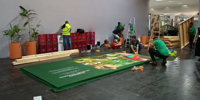 Foto colorida de pessoas trabalhando em montagem de estrutura para a COP30