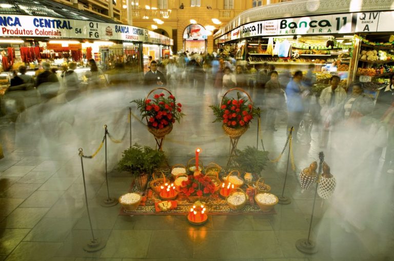 Foto colorida de oferendas durante festa do Bará do Mercado Público de Porto Alegre