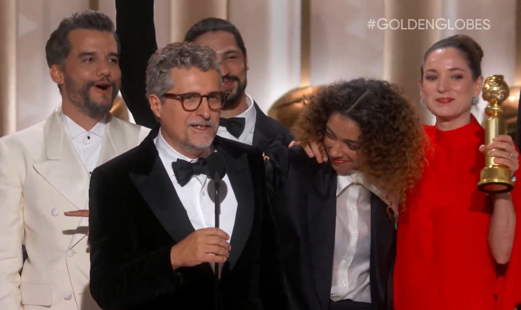 Kleber Mendonça Filho com o elenco de O Agente Secreto ao receber o Globo de Ouro de Melhor Filme em Língua Estrangeira: sem fingir costume (Foto: Reprodução / Golden Globes)