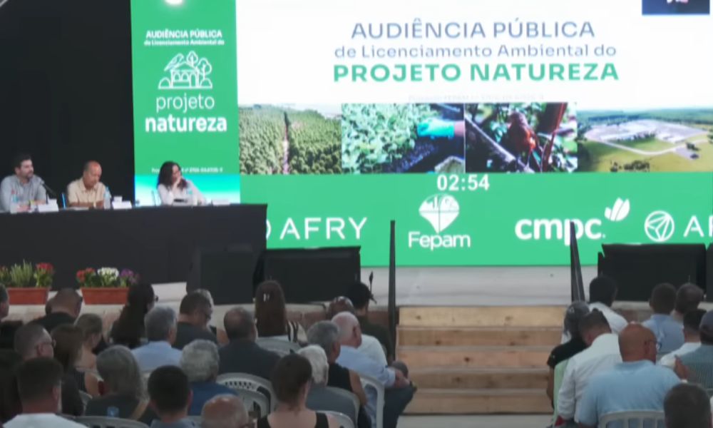 Captura de tela colorida que mostra tela de audiência pública sobre a fábrica de celulose com a imagem da área de impacto do empreendimento em Barra do Ribeiro e na bacia do Guaíba