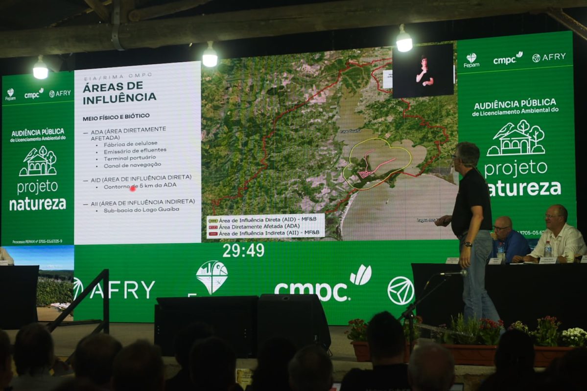 Foto colorida que mostra tela de audiência pública sobre a fábrica de celulose com a imagem da área de impacto do empreendimento em Barra do Ribeiro e na bacia do Guaíba