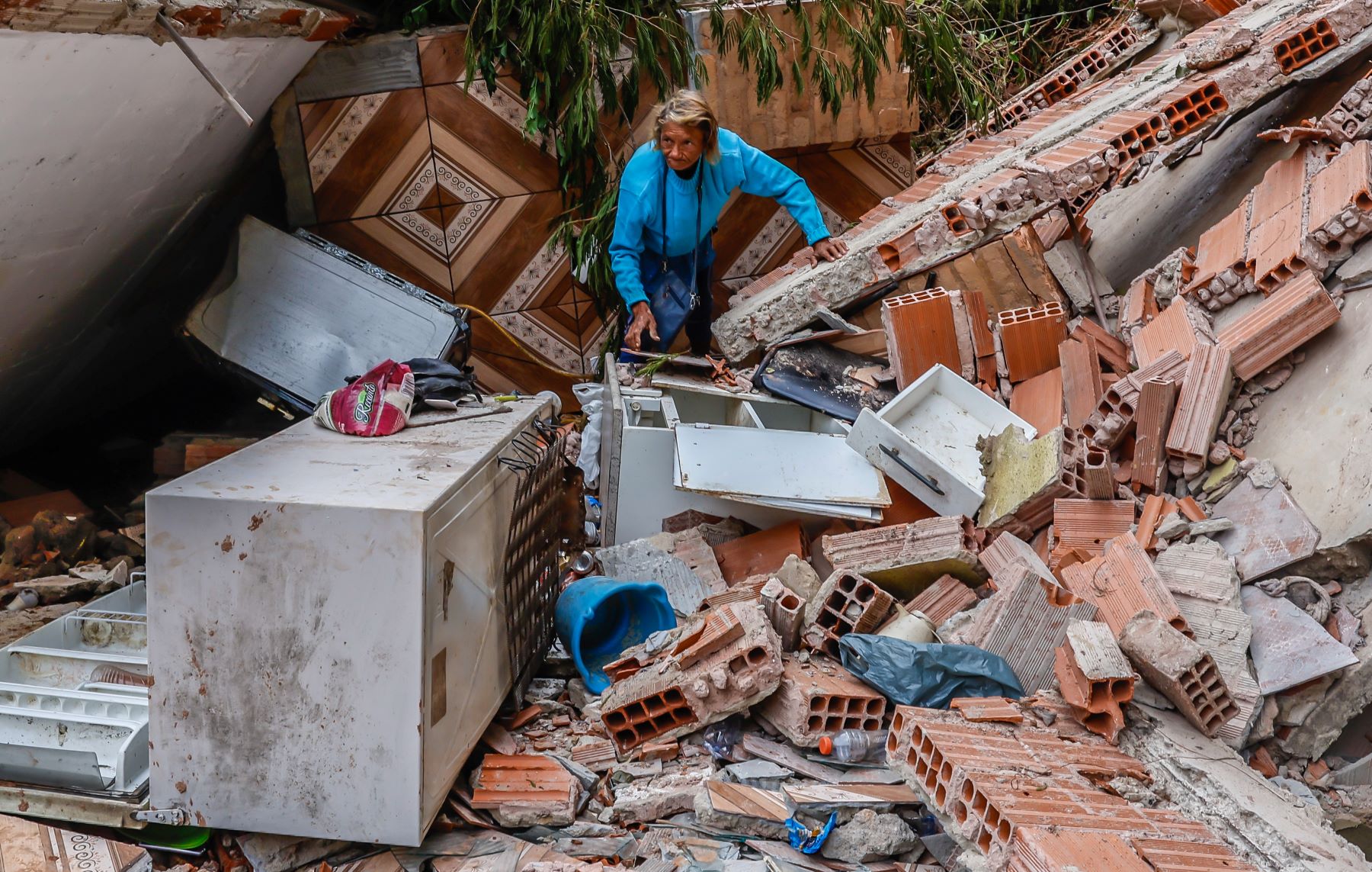 Moradora do bairro Três Moinhos, em Juiz de Fora, busca pertences na casa destruída pelos temporais: a dor da gente também sai jo jornal (Foto: Tânia Rego / Agência Brasil - 01/03/2026)