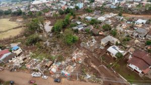 Foto colorida com vista aérea de como ficou a cidade de Muçum após as enchentes de setembro de 2023. Na imagem, diversas casas destruídas