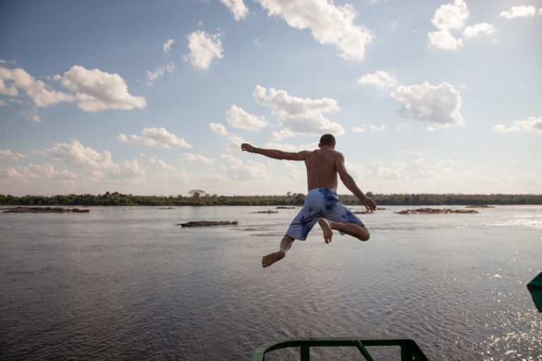 Foto colorida que mostra homem sem camisa pulando no rio. Comunidade Quilombola Forte Príncipe da Beira, na fronteira entre Rondônia e Bolívia (Foto: Avener Prado/ FESTCINEAMAZONIA/2013).