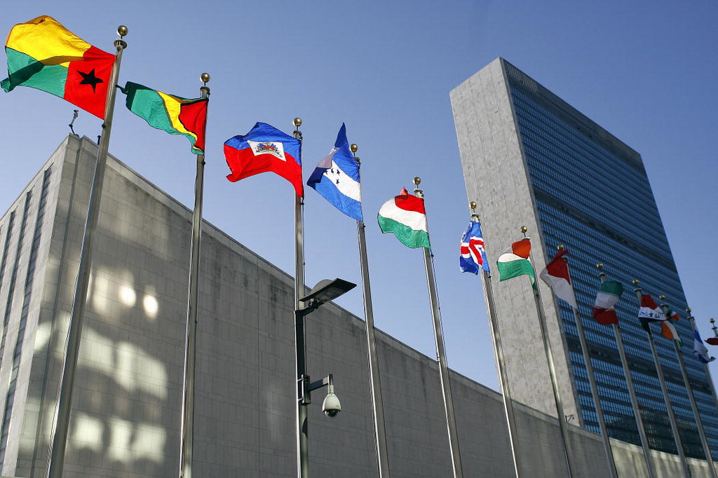 Foto colorida do prédio da Corte Internacional de Justiça com várias bandeiras tremulando; imagem ilustra votação para definir se mudança do clima é obrigação legal dos países