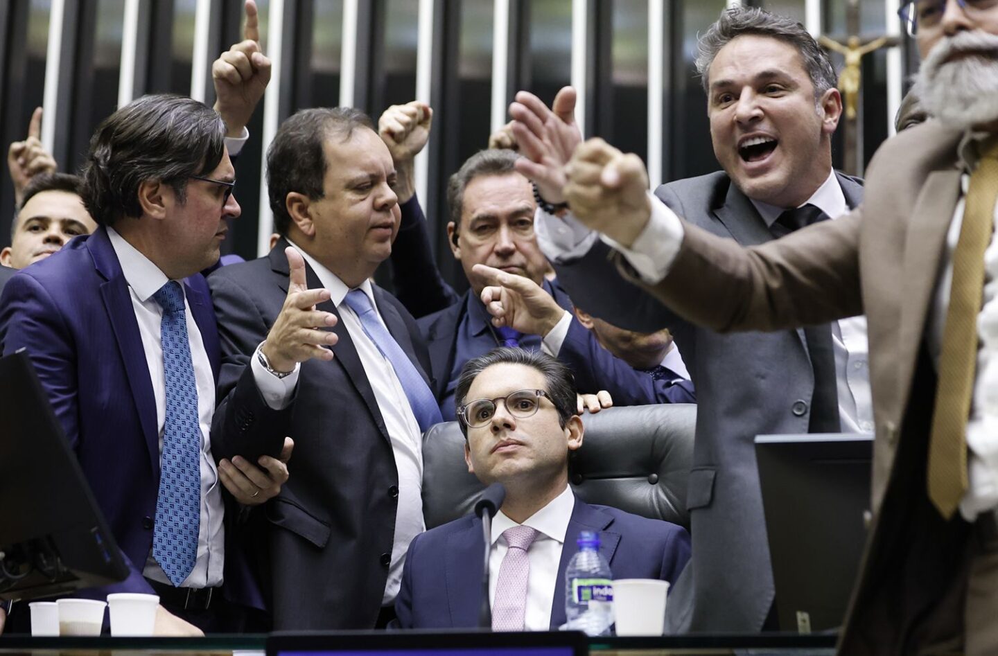 Foto colorida que mostra o deputado Hugo Motta, sentado no plenário da Câmara e cercado por deputados da direita; bancada ruralista se articulou para atacar legislação ambiental
