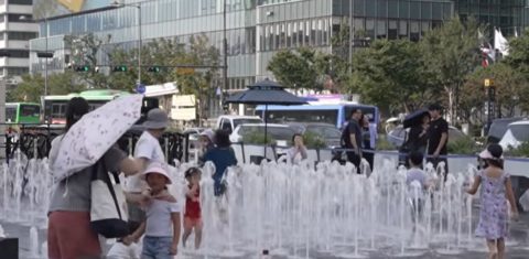 Crianças se refrescam em chafariz em Seul: Coreia do Sul enfrenta temperatura recorde e mais de 20 mortes por calor (TV AL Jazeera / Reprodução)
