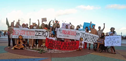 Foto colorida de várias pessoas reunidas com faixas em protesto contra o possível desmatamento de área da APA Aldeia-Beberibe para construção da escola de sargentos, em Pernambuco