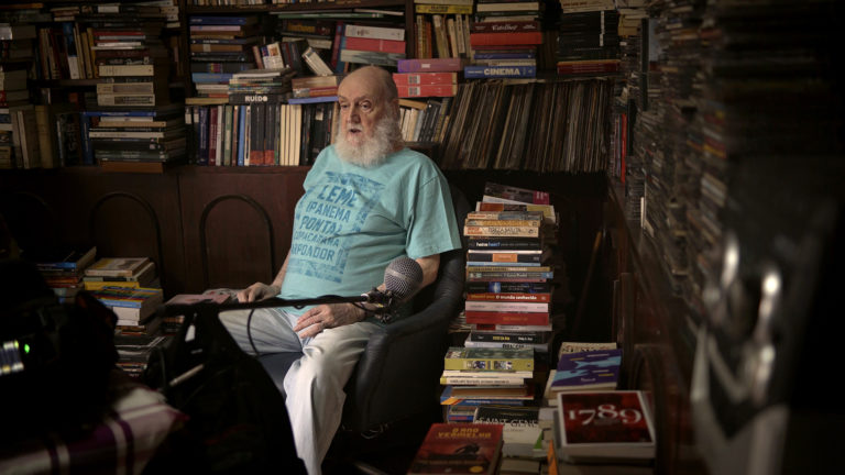 O compositor e escritor em sua biblioteca durante as filmagens de Aldir Blanc - Resposta ao Tempo: homenagens para "o ourives do palavreado" (Foto: Divulgação)