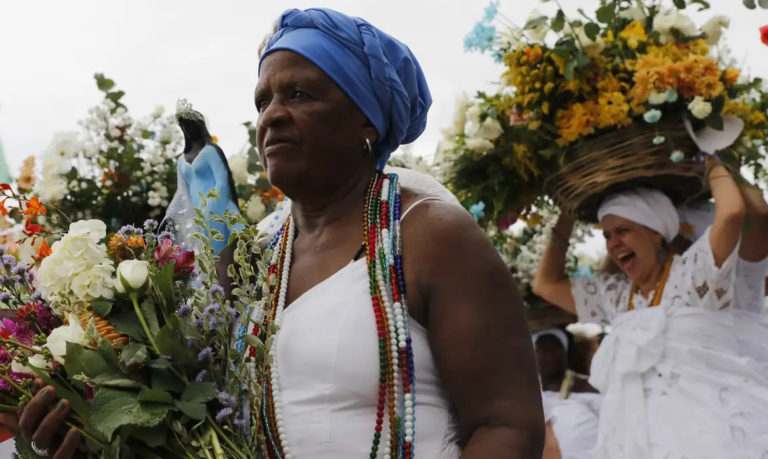 Foto colorida de mulher preta nas ruas de Salvador, Bahia, em celebração religiosa de matriz africana. Foto: Fernando Frazão/ Agência Brasil