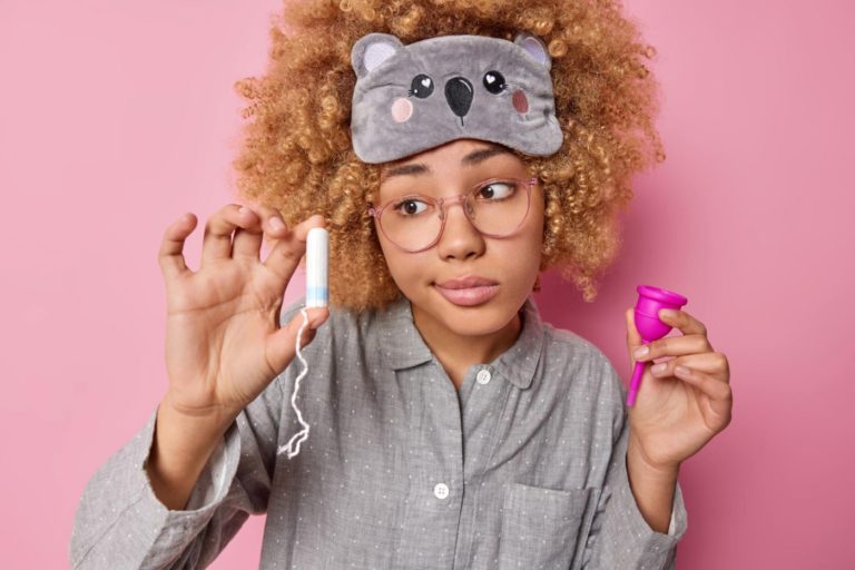 Modelo mostra absorvente interno e coletor menstrual: itens básicos de higiene menstrual (Foto: Wayhomestudio / freepik / magnific)
