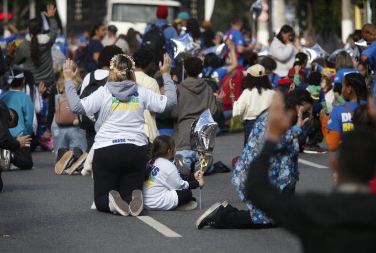 Fieis se ajoelham para orar durante a 32ª edição da Marcha para Jesus em São Paulo: futuro da transição religiosa no Brasil tem ritmo de avanço evangélico como variável (Foto: Paulo Pinto / Agencia Brasil - 30/05/2024)