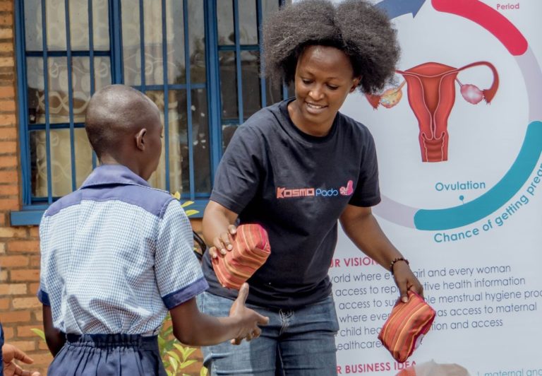 Blandine na distribuição de absorventes para meninas: cultura e diálogo estão ajudando a quebrar tabus e ampliar o acesso à saúde menstrual em Ruanda (Foto: Divulgação)
