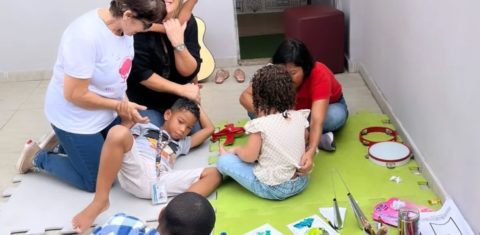 A psicopedagoga Rosane Araújo é abraçada por aluno durante atividade na clínica em que trabalha: a ausência de diagnósticos precoces ainda provoca um apagamento cruel (Foto: Reprodução / Facebook)
